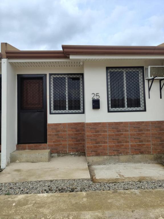 a brick house with a black door and windows at JV tRansient 24 in Ormoc