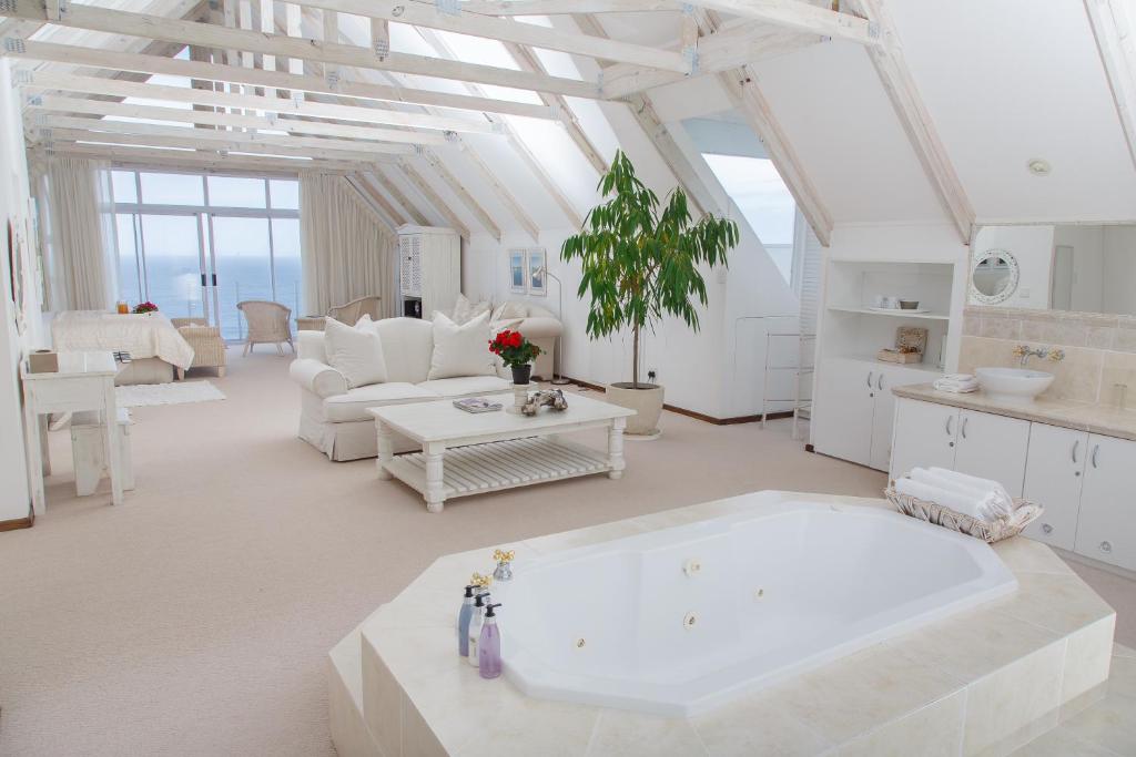 una gran sala de estar blanca con una gran bañera en Whales Way Ocean Retreat, en Wilderness