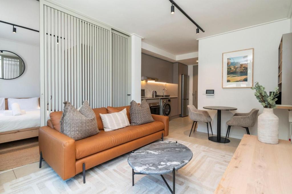 a living room with a couch and a table at Lavish Living at The Braemar in Cape Town