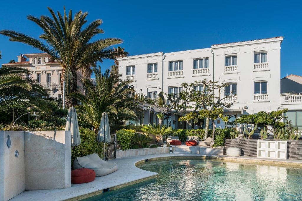 un hôtel avec une piscine devant un immeuble dans l'établissement Le Petit Nice - Passedat, à Marseille