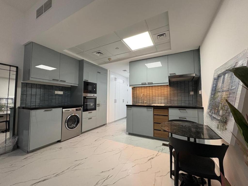 a kitchen with a washer and dryer and a table at Studio at Bab Al Bahr RAK in Ras al Khaimah