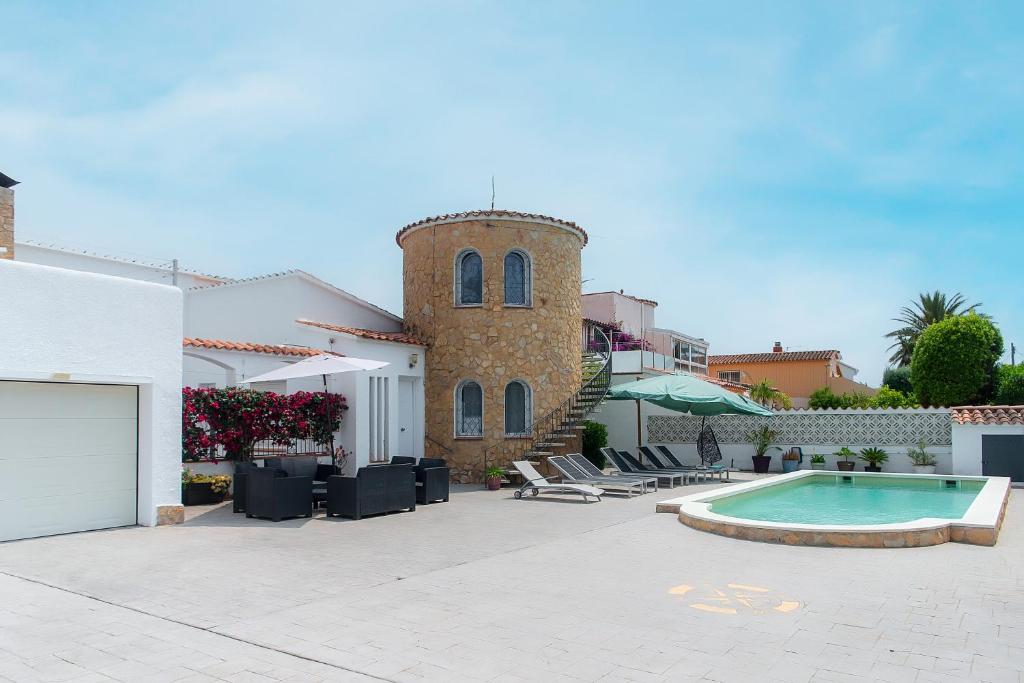 une villa avec une piscine et un bâtiment dans l'établissement WELCS CASA 111 EMP con piscina, à Empuriabrava
