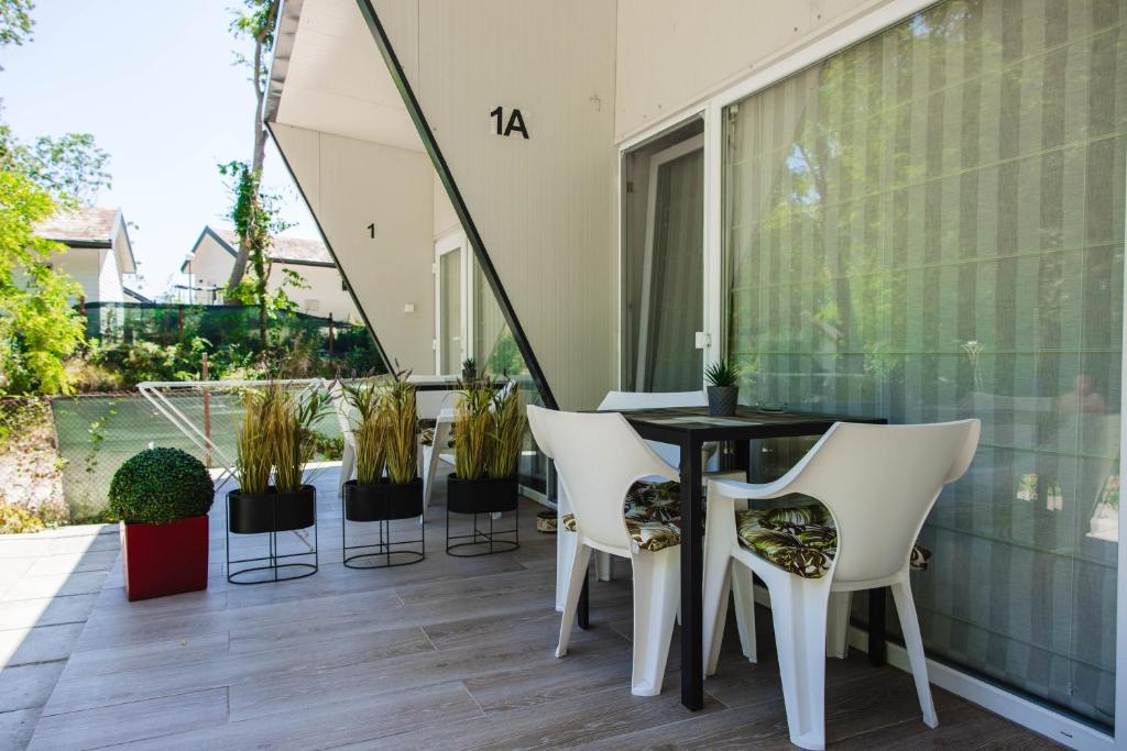 a balcony with a black table and white chairs at Albatross Breeze Bungalow 100m from the beach in Varna City