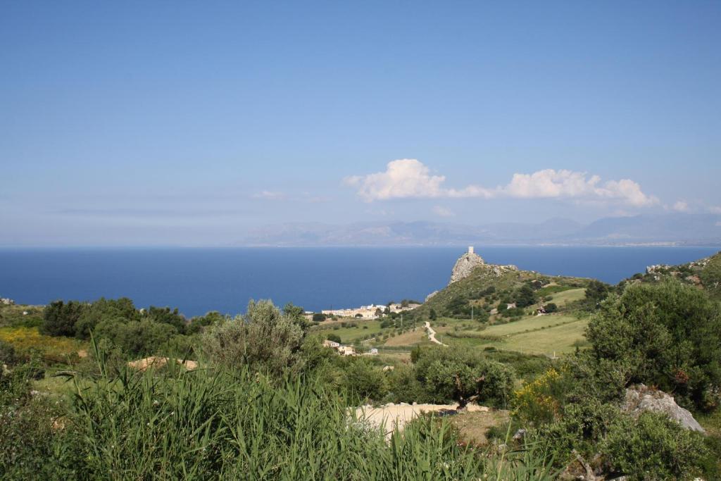 uitzicht op de oceaan vanaf een heuvel met bomen bij Villa Rossana in Scopello