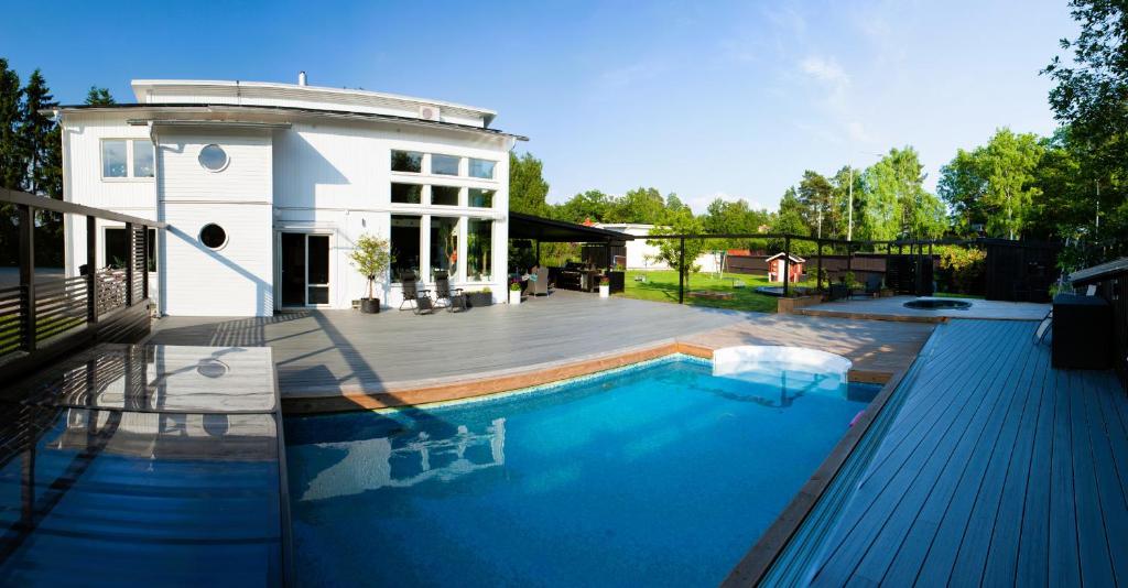 a swimming pool in front of a house at Luxury villa Stockholm in Ågesta
