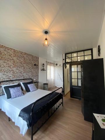 une chambre avec un lit et un mur de briques dans l'établissement La belle campagne, à Granges-dʼAns