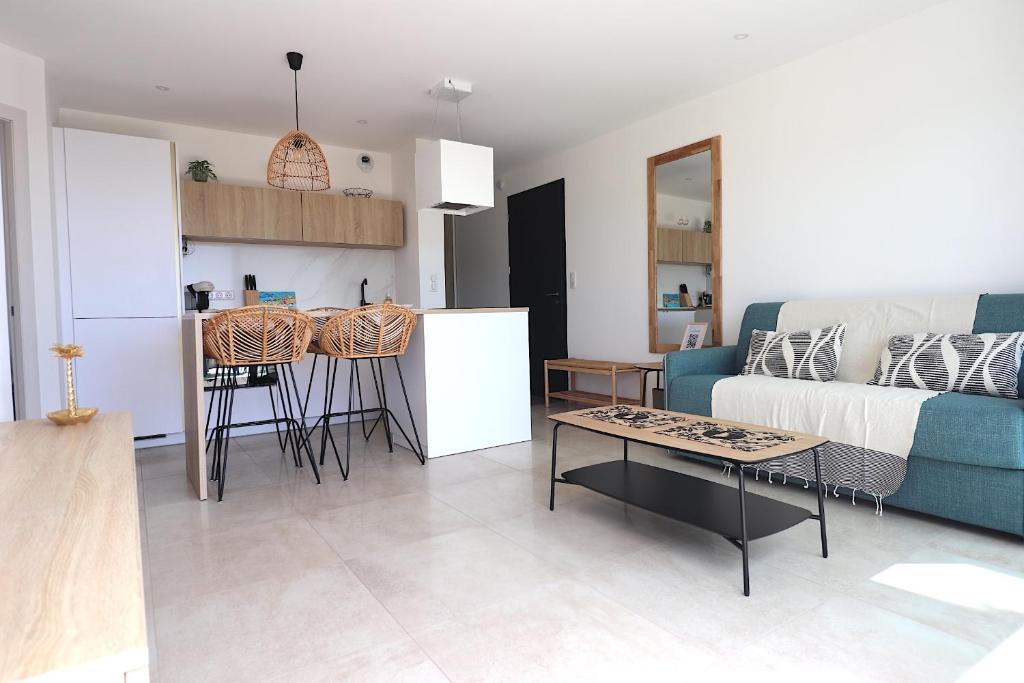 Il dispose d'une cuisine et d'un salon avec un canapé et une table. dans l'établissement T3 Villas Acum - Le Bohème - Excellente situation géographique - domaine de Standing - Vue mer, à Grosseto-Prugna