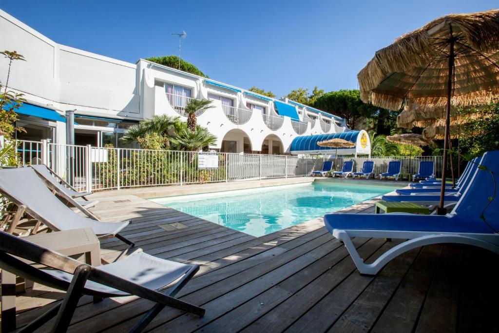 uma piscina com espreguiçadeiras e um guarda-sol em Hotel Europe em La Grande-Motte