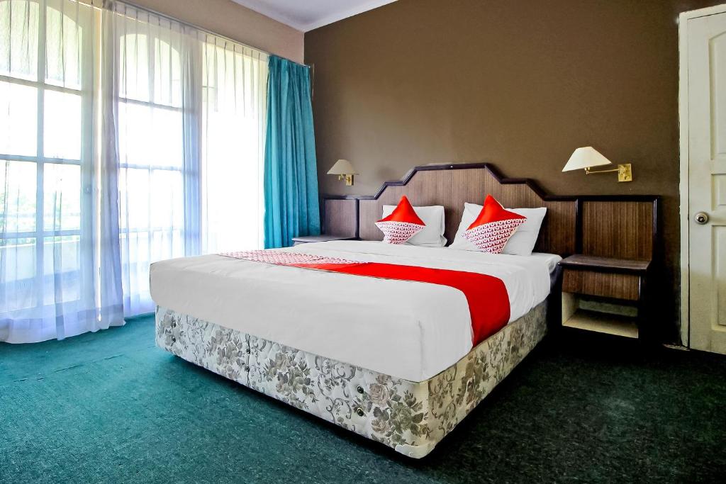 ein Schlafzimmer mit einem großen Bett mit roten Kissen in der Unterkunft OYO 2360 Hotel Rio in Bengkulu