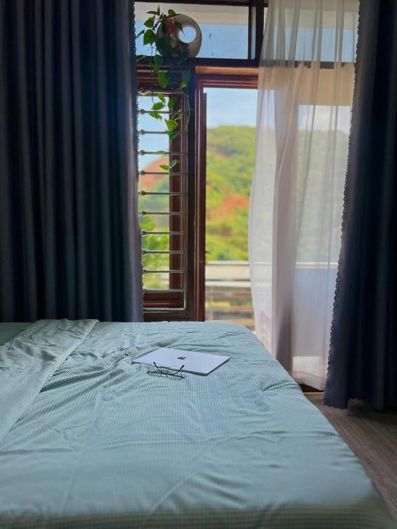 a bed in a room with a window with at Đá Gió Hà Giang Homestay in Ha Giang