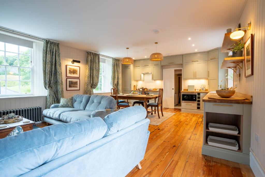 a living room with a blue couch and a table at Penninghame Estate - Earl's Library in Challoch