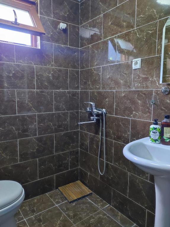 un bagno con doccia, WC e lavandino di Ushba House a Mestia