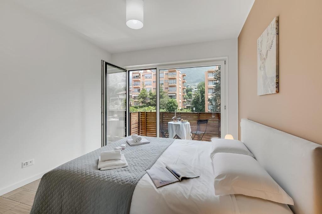 Viganello Modern Apartments في لوغانو: غرفة نوم بسرير كبير عليها منشفتين