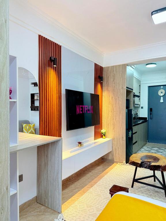 a living room with a television on a wall at my cozy place in Nairobi