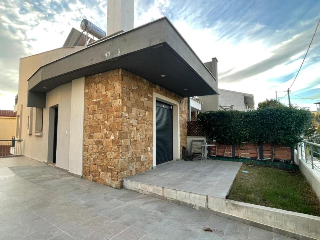 a house with a brick wall and a garage at Phaedra Residence in Nikiti