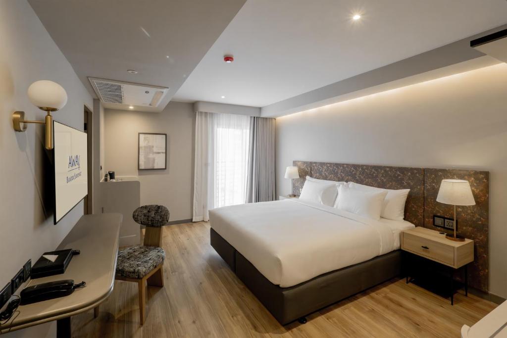A bedroom with a king bed and a narrow console-style work surface.