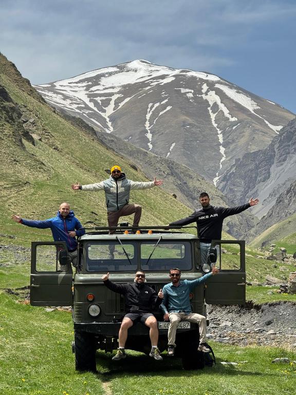 a group of people sitting on the roof of a jeep at Xinaliq Khinalig İzzet's Riverside Home Stay in Xınalıq