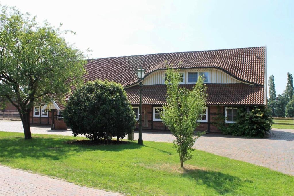 un edificio con dos árboles delante de él en Stilvolles Landhaus mit Flair, en Menslage