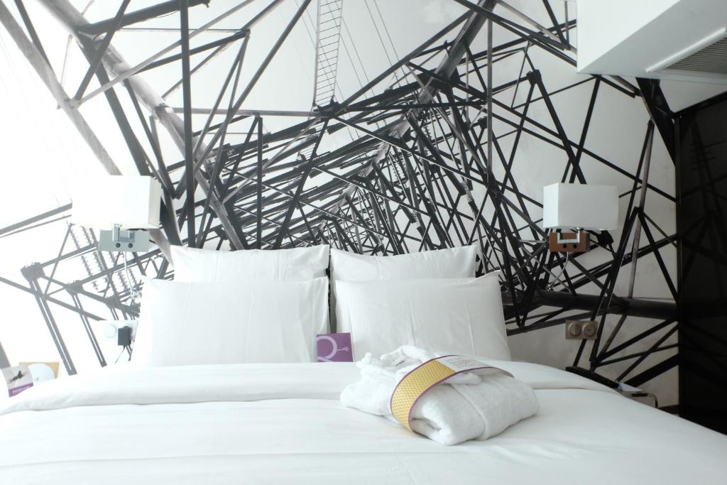 - une chambre avec un lit blanc et un mur en métal dans l'établissement Mercure Paris Malakoff Parc des Expositions, à Malakoff