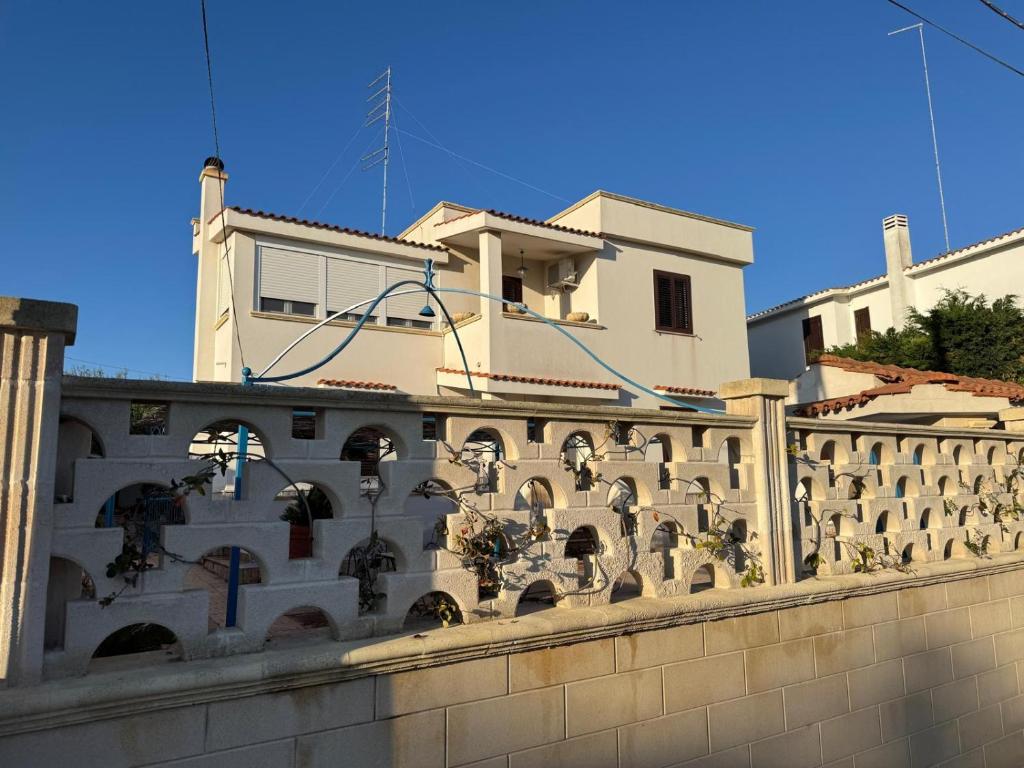 a stone wall with a building in the background at Villa Lucia appartamento Capri in Leporano Marina
