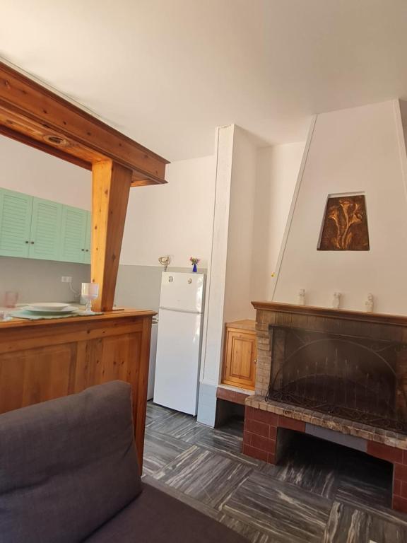 a living room with a fireplace and a white refrigerator at Modern traditional tranquil house with garden in Nea Makri