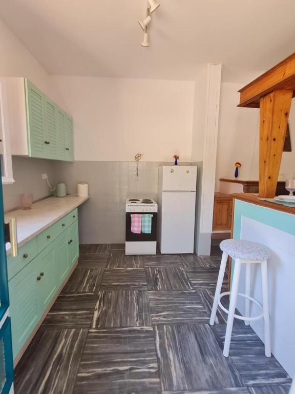 a kitchen with green cabinets and a white refrigerator at Modern traditional tranquil house with garden in Nea Makri