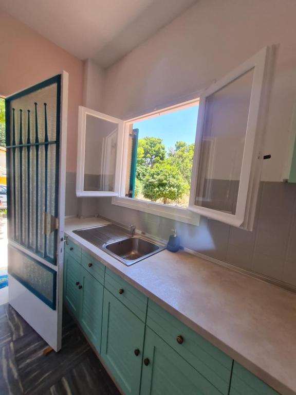 a kitchen with a sink and a window at Modern traditional tranquil house with garden in Nea Makri