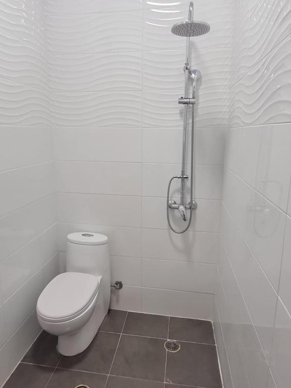 a white bathroom with a toilet and a shower at Modern traditional tranquil house with garden in Nea Makri
