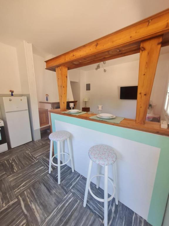 a kitchen with a counter and two stools at Modern traditional tranquil house with garden in Nea Makri