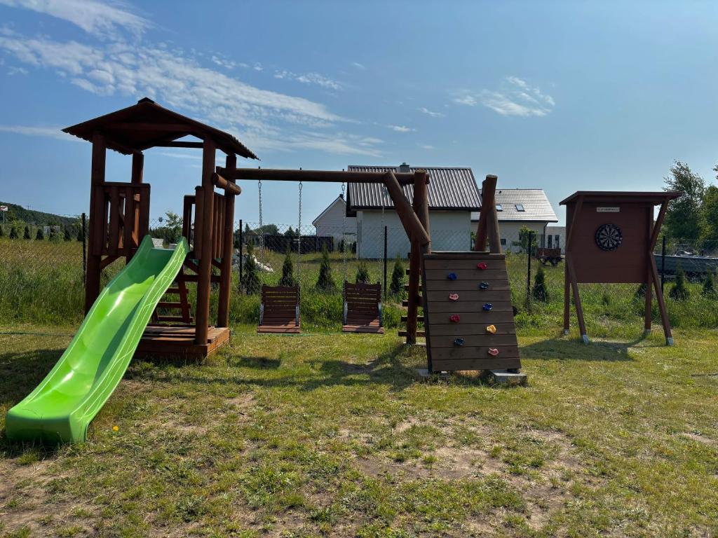 un parco giochi con scivolo verde e gazebo di Domki Wypoczynkowe LUBKOWIA a Lubkowo