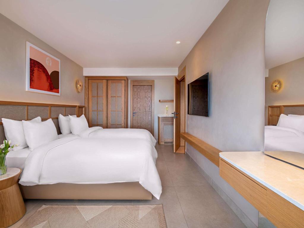 a hotel room with two beds and a television at Rixos Premium Tekirova - The Land of Legends Access in Tekirova