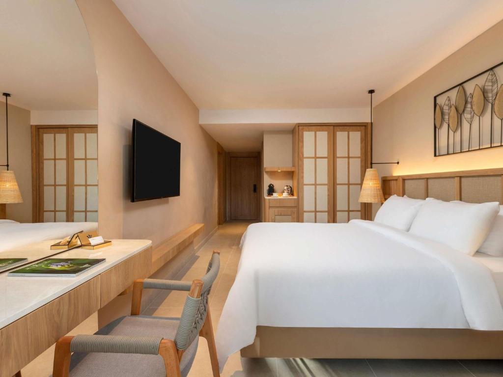 a hotel room with a large bed and a desk at Rixos Premium Tekirova - The Land of Legends Access in Tekirova