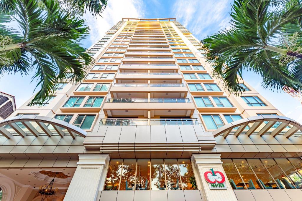 胡志明市舍伍德公寓式酒店的一座前面有棕榈树的高楼