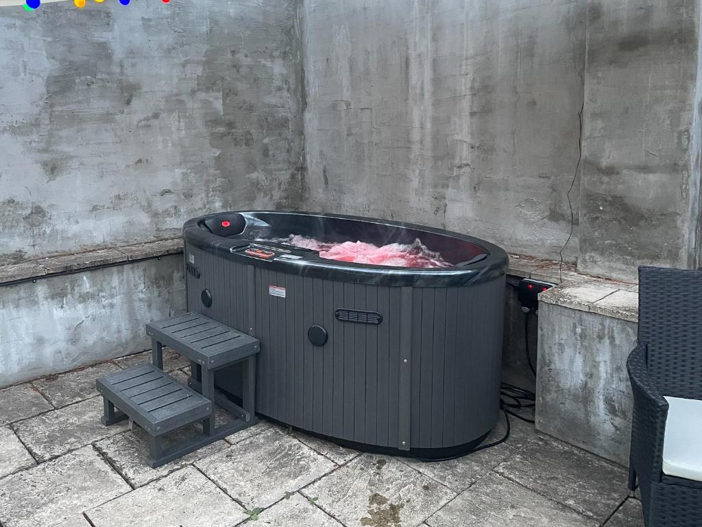a trash can and a stool next to a wall at Orchard Bank Cottage in Longhope