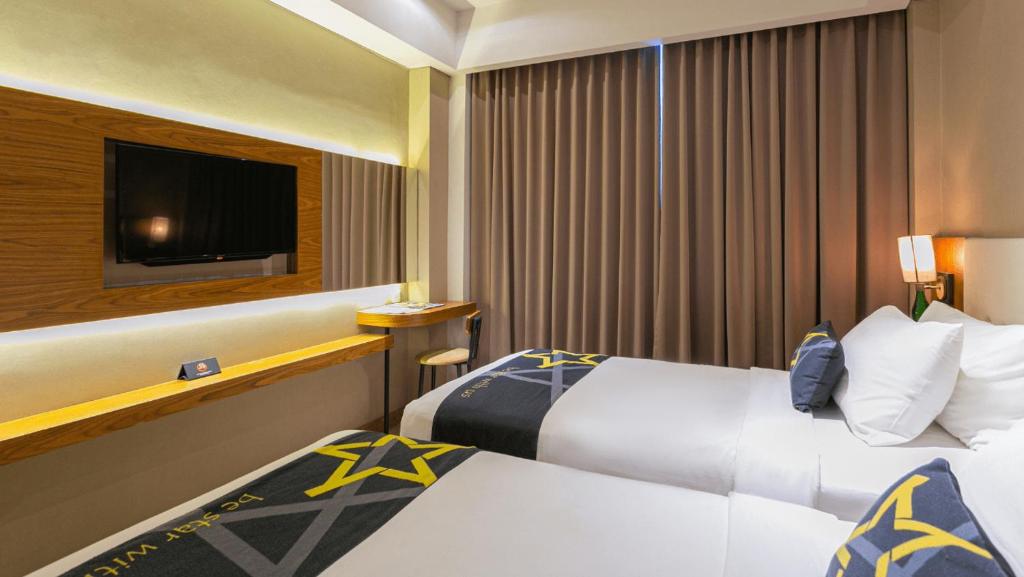 Postel nebo postele na pokoji v ubytování Yellow Star Gejayan Hotel