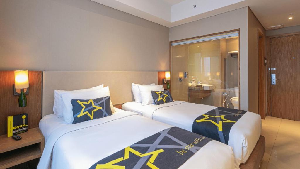 Postel nebo postele na pokoji v ubytování Yellow Star Gejayan Hotel