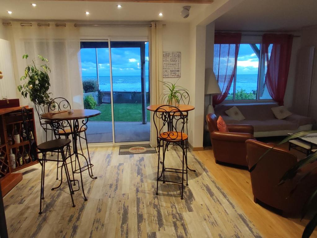 a living room with two bar stools and a couch at Face a la mer in Courseulles-sur-Mer