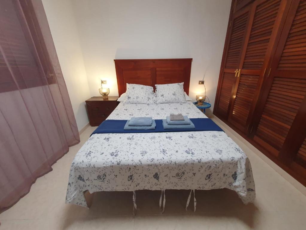 a bedroom with a bed with a blue and white comforter at alquilaencanarias Tio Claudio Beach in El Médano