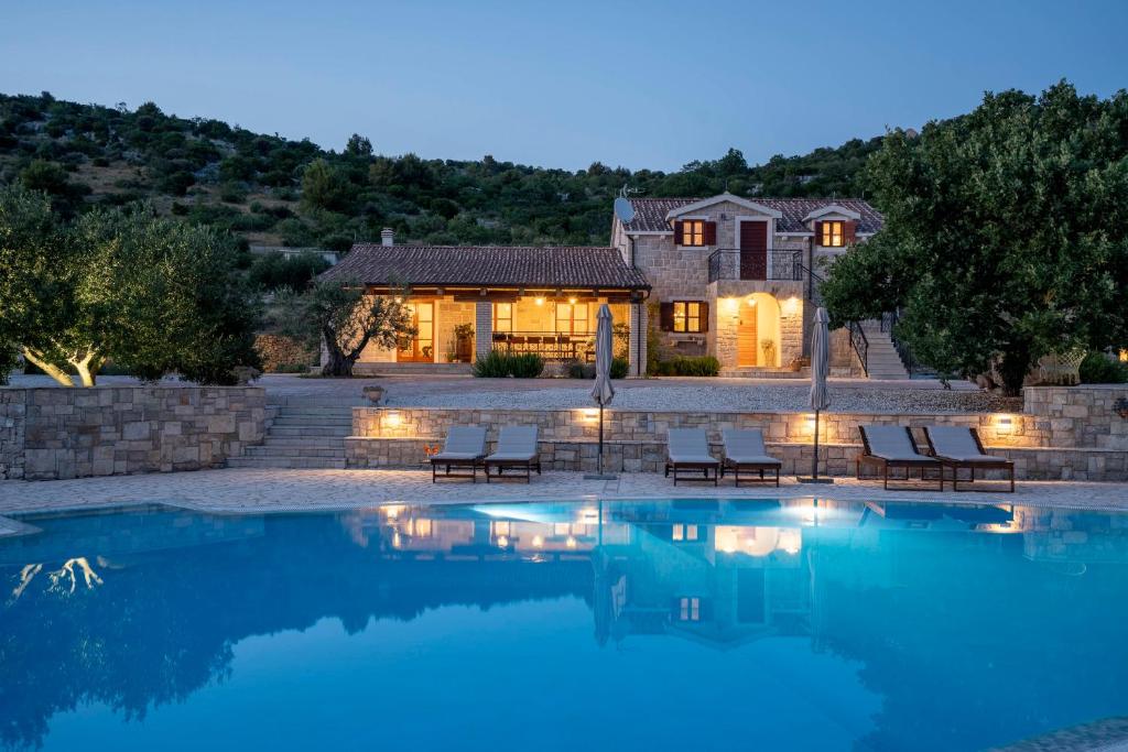 a house with a swimming pool in front of a house at Lavanda Mansion in Vodice