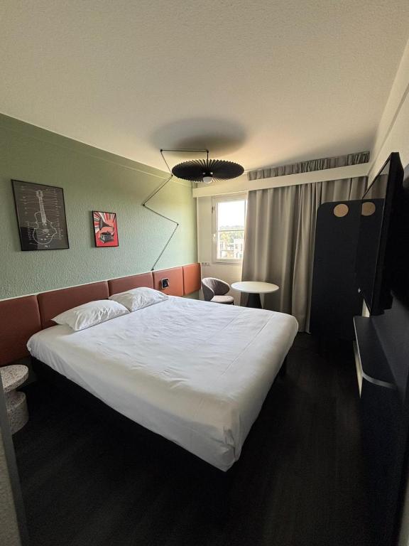 une chambre avec un grand lit blanc dans une pièce dans l'établissement ibis Strasbourg Aéroport Le Zénith, à Lingolsheim