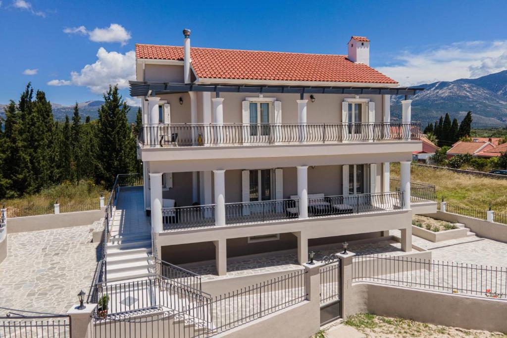 a large white house with a red roof at Irene Luxury Apartments in Metaxáta