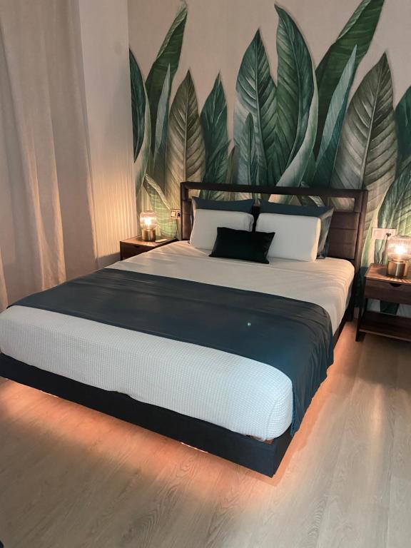 a bedroom with a large bed with a large plant on the wall at Oasis de Paz Cullera in Cullera