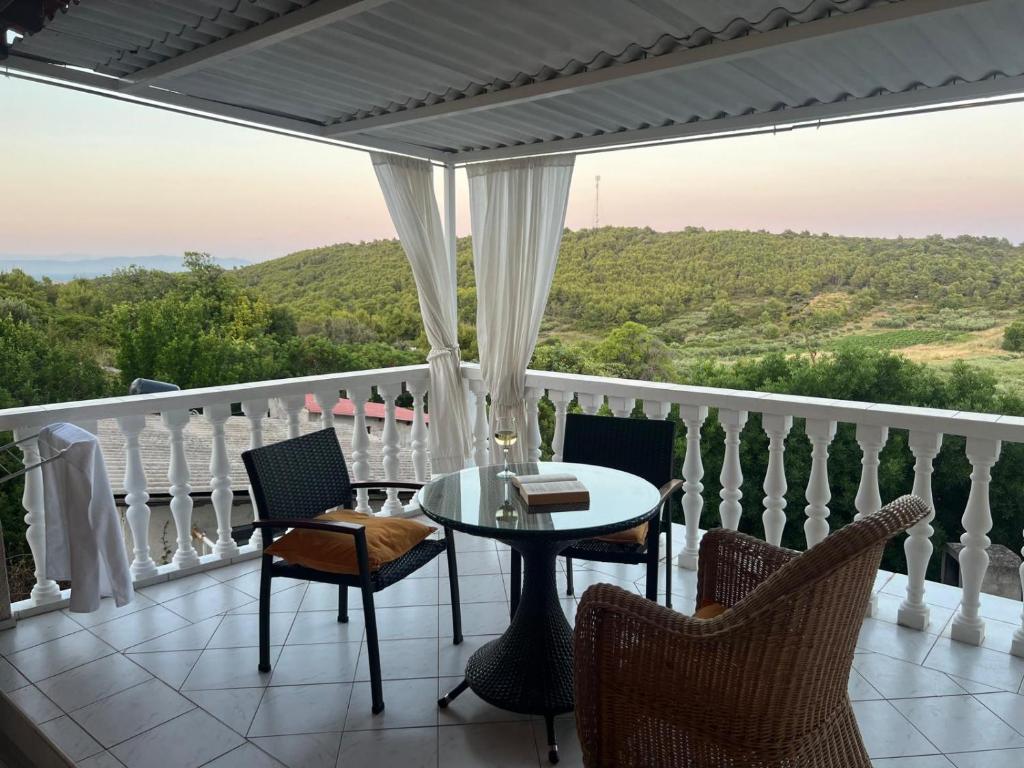 a balcony with a table and chairs and a view at Apartments Elena & Damir in Vis