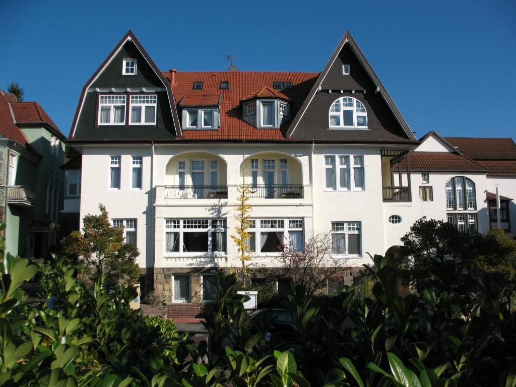 un grand bâtiment blanc avec un toit noir dans l'établissement Kurvilla Fürstin Pauline, à Bad Salzuflen