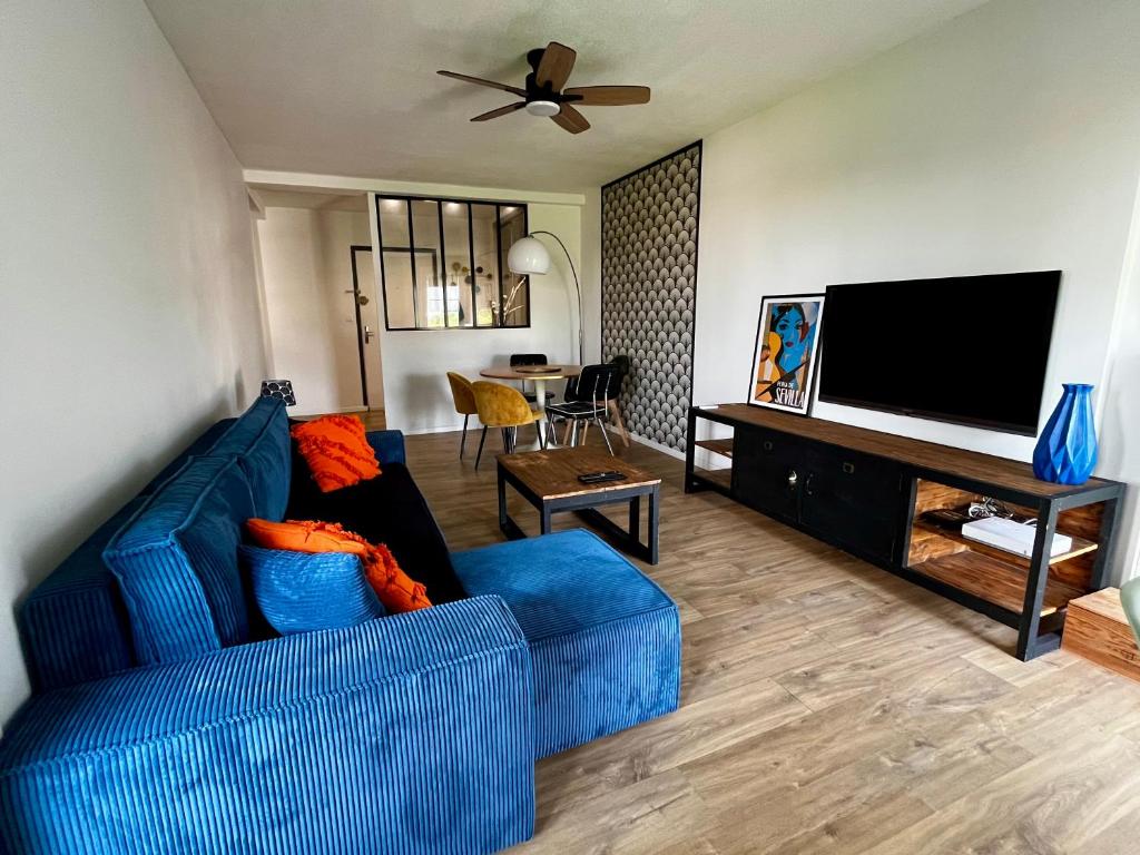 un salon avec un canapé bleu et une télévision à écran plat dans l'établissement La Sevillana - 3 Bedrooms - Cute Terrace - 2 Parkings, à Toulouse