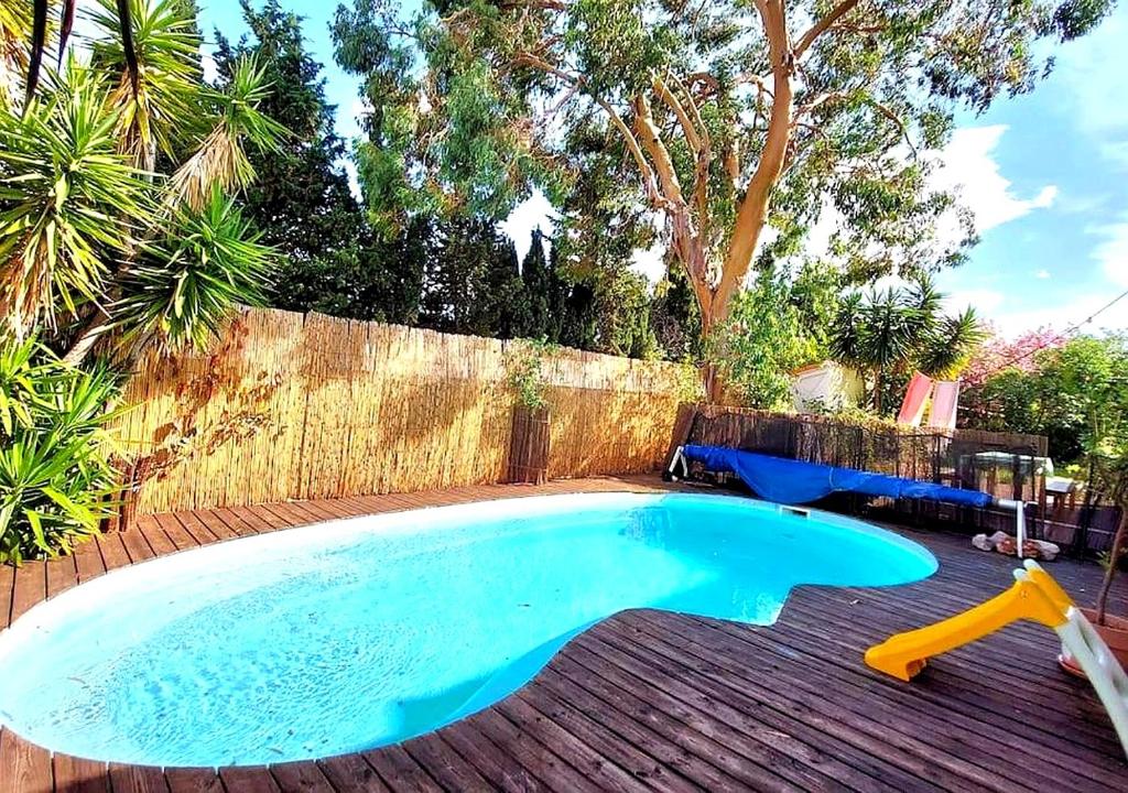 a swimming pool in a backyard with a yellow pool toy at Villa avec jardin et piscine privés in Montpellier