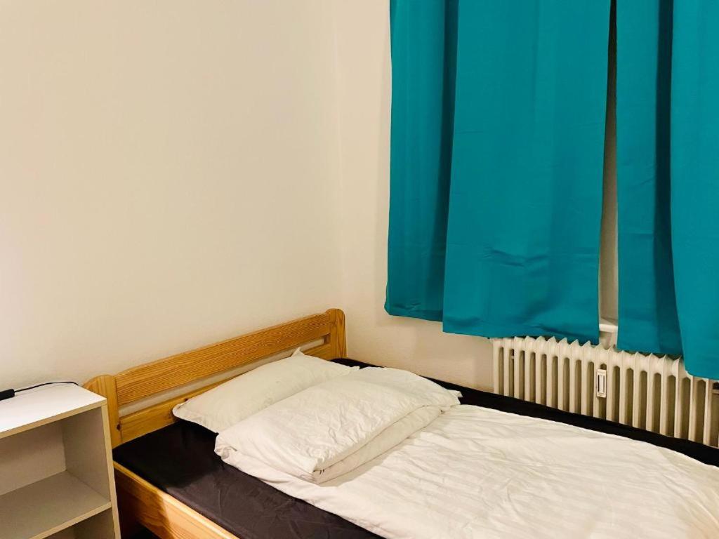 Un dormitorio con una cama con cabecero de madera y una cortina azul. en New Living Nest, en Seevetal