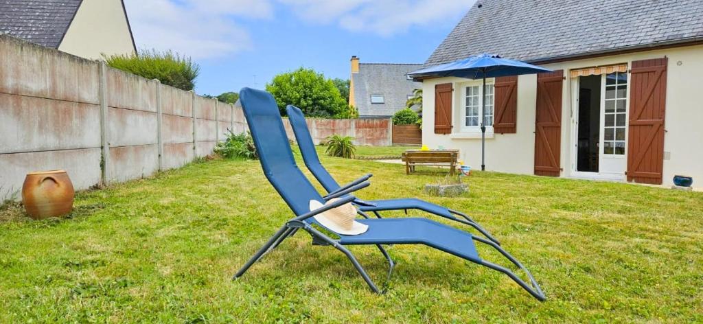 a blue chair sitting in the grass in a yard at Ti maeronez in Paimpol