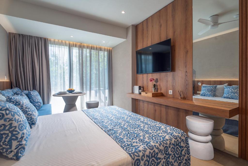 a hotel room with a bed and a television at Cozy Suite in Rhodes Town