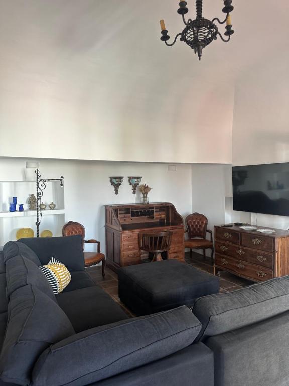 a living room with a couch and a flat screen tv at Solar de Arrayollos by PURUS in Arraiolos